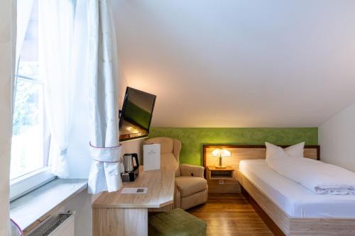 a hotel room with a bed and a television at Königshof Hotel Resort in Oberstaufen