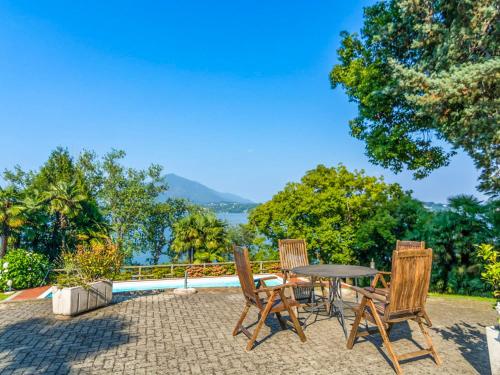 un patio con tavolo, sedie e vista sull'acqua di Residenza Verde Lago a Stresa