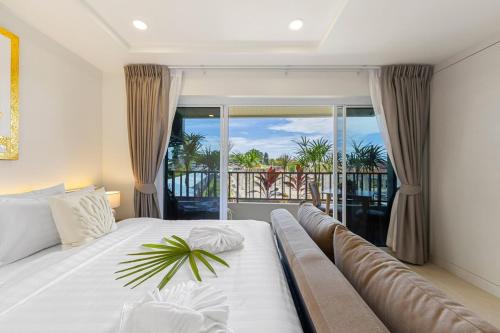 a bedroom with a large bed and a balcony at The Terraza Studio A303 in Amphoe Koh Samui