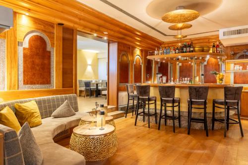 a living room with a couch and a bar at Königshof Hotel Resort in Oberstaufen