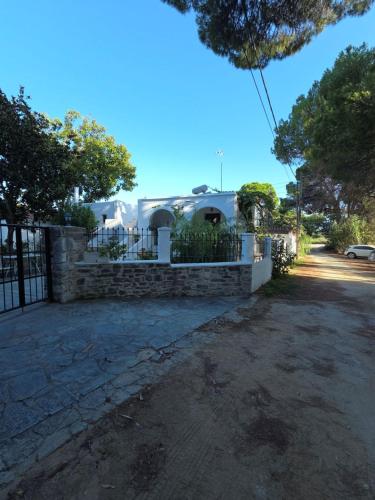 a house with a fence and a driveway at 3 Goddesses' studios in Koukounaries