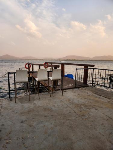 a table and chairs on a dock in the water at Le Bamboo Guest House And Boat Cruise in Hartbeespoort