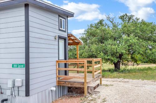 a tiny house with a porch on the side of it at Inn Spired at Bent Tree Ranch in Lampasas