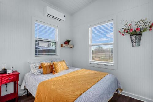 a bedroom with a bed and two windows at Inn Spired at Bent Tree Ranch in Lampasas