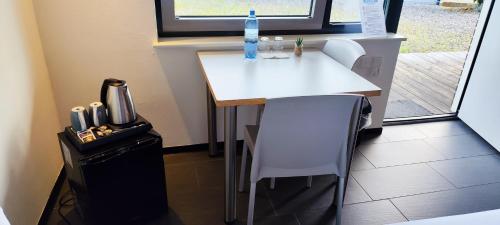 a small white table in a room with a window at Sport Arena HOTEL Waldshut in Waldshut-Tiengen