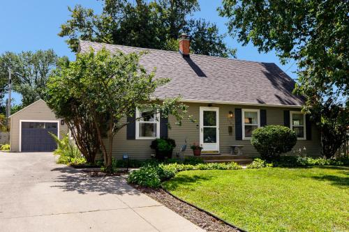 a small green house with a driveway at Crane Haven - Walk to CyRide Games & Grill in Ames