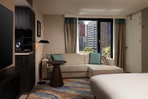a hotel room with a couch and a window at Haven Hotel Rotterdam, Curio Collection by Hilton in Rotterdam