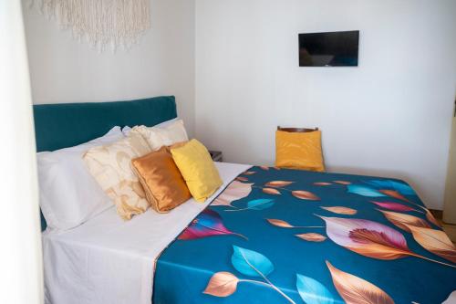 a bed with colorful pillows on it in a room at Sunrise Place Casa Vacanze in Praia a Mare