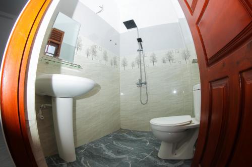 a bathroom with a toilet and a shower and a sink at Ever Top Resort Kithulgala in Kitulgala