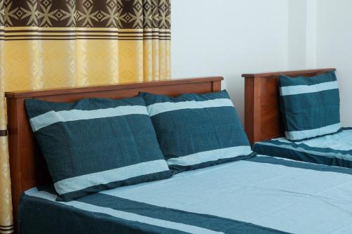 a bedroom with two beds with blue sheets and pillows at Ever Top Resort Kithulgala in Kitulgala