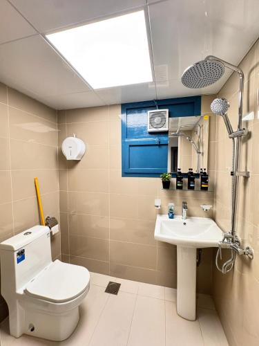 a bathroom with a toilet and a sink at Vogue Inn Abu Dhabi in Abu Dhabi
