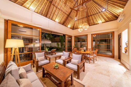 an open living room with a couch and a table at Jimbaran Beach Villas by Nakula in Jimbaran
