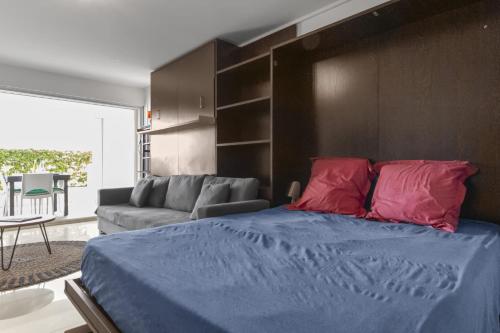 a bedroom with a bed with blue sheets and red pillows at Marigot Bay in Saint Martin