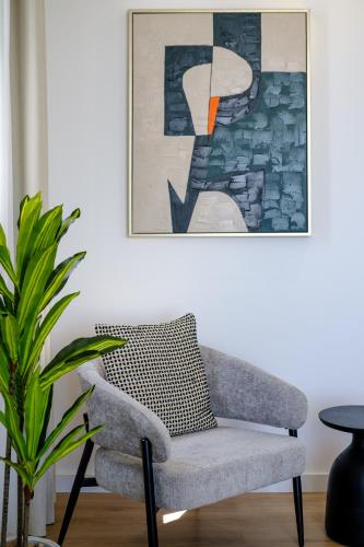a chair in a living room with a painting at Artemis 202 - Seaside Stories in Livadhia