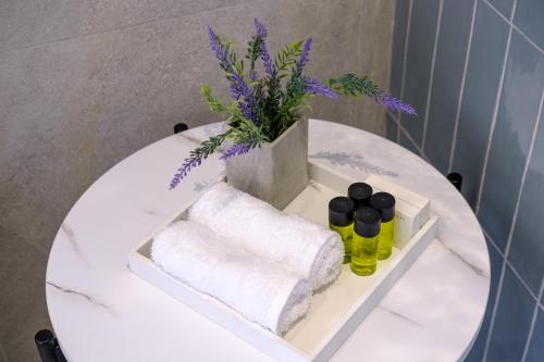 a white table with towels and a vase of flowers at Artemis 202 - Seaside Stories in Livadhia