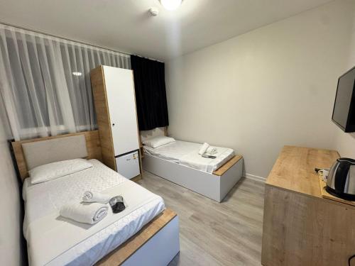 a small room with two beds and a tv at QLİNE HOTEL AİRPORT SaW in Istanbul