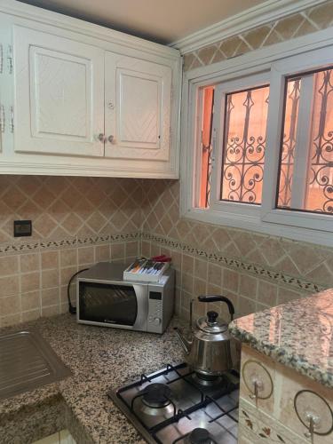 a kitchen with a stove and a microwave on a counter at Riad Nour Resorts-Riad Nour Travel in Marrakech