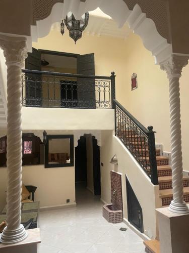 a hallway with white columns and a staircase at Riad Nour Resorts-Riad Nour Travel in Marrakech