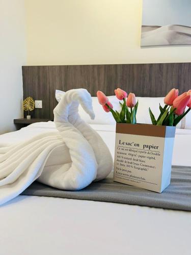 a white seahorse sitting on a bed next to a box at The Horizon Ipoh By Iconique Espace in Ipoh