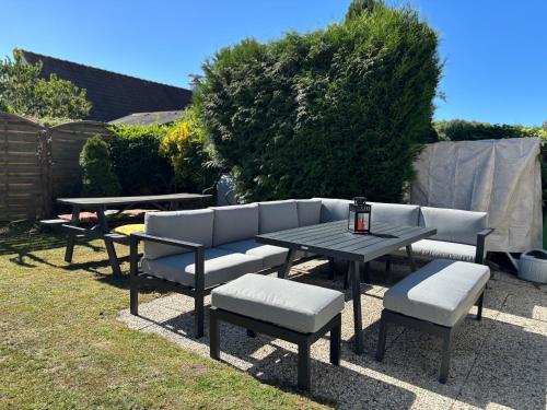a patio with a table and chairs and a table and benches at Maison Duinendaele 101 - De Panne in De Panne