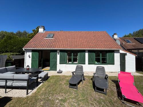 a house with a table and chairs in the yard at Maison Duinendaele 101 - De Panne in De Panne
