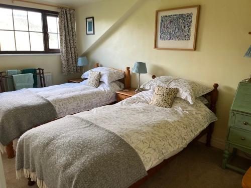 una camera da letto con due letti e una finestra di Kilsby Cottage a Llanwrtyd Wells