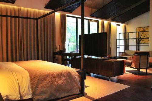 a bedroom with a bed and a desk with a computer at Shangyin Chuanbu Holiday Manor in Huzhou