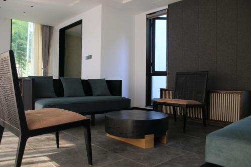 a living room with a couch and chairs and a table at Shangyin Chuanbu Holiday Manor in Huzhou