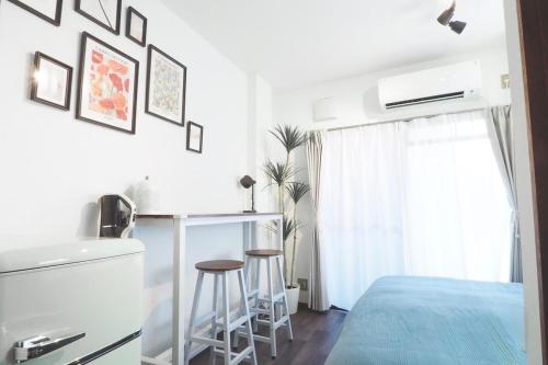 a bedroom with a bed and a table and two stools at Etoile Kagurazaka-Queen Room near Shinjuku, Self Check-in in Tokyo