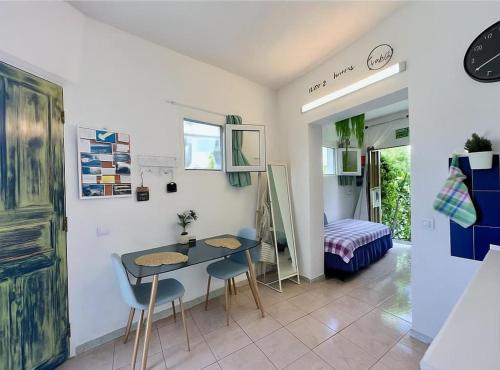 Una habitación con una mesa y sillas y un dormitorio. en Happy Home, en Garachico