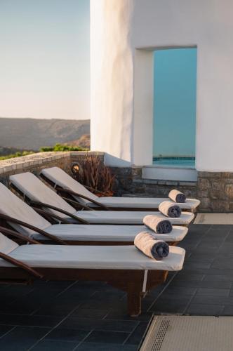 a row of chaise lounges on a patio at Vigla Hotel in Aegiali