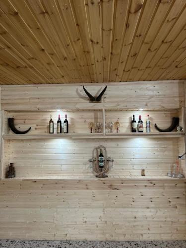 a room with wooden walls and shelves with wine bottles at Bata GuesThouse in Adishi
