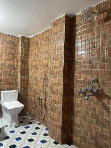 a bathroom with a shower and a toilet in a room at Hotel Aman Residency & Restaurant in Nalanda