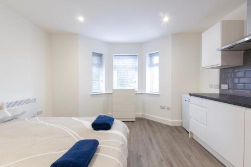 a white bedroom with a bed and a kitchen at Radstock Road - Room 1b in Southampton