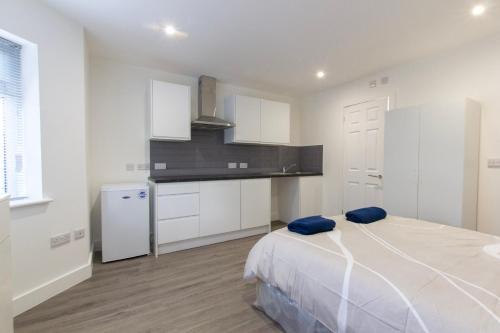 a white kitchen with a bed in a room at Radstock Road - Room 1b in Southampton