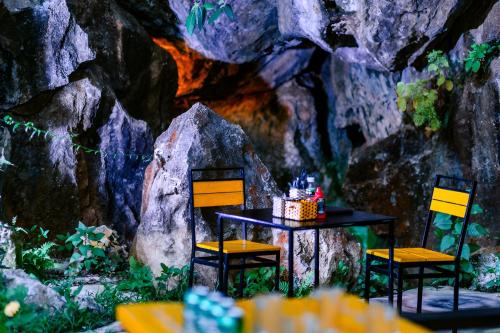 a table and two chairs in a room with rocks at Song Toan Hotel in Phong Nha