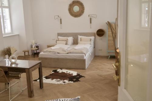 a white bedroom with a bed and a table at City Stay Vienna – Stephansdom in Vienna
