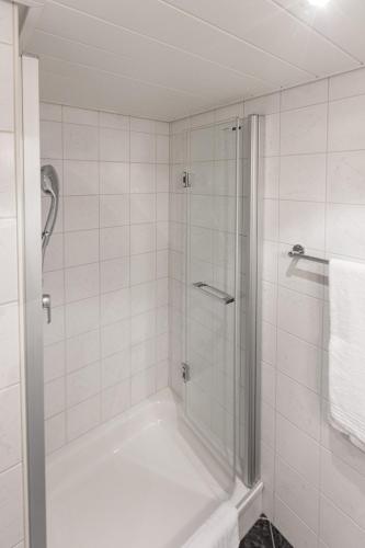 a white bathroom with a shower and a tub at Hotel und Restaurant zum goldenen Kopf in Bülach