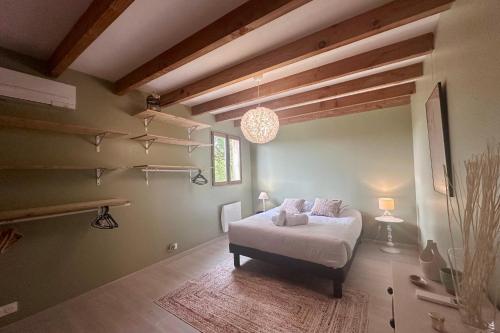 a bedroom with a bed in a room with wooden ceilings at Chalet de Russac - 6 personnes - Jardin clôturé avec terrasse aménagée in Turenne