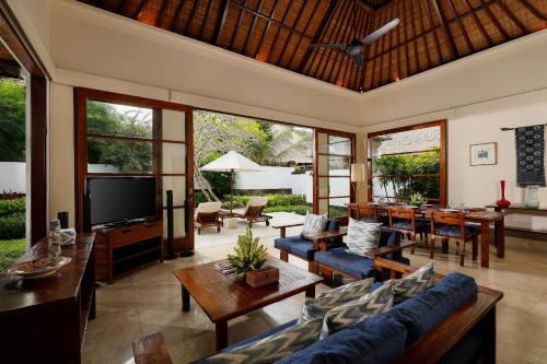 a living room with a couch and a tv at Jimbaran Beach Villas by Nakula in Jimbaran
