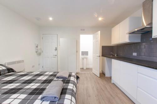 a kitchen with white cabinets and a bed in a room at Radstock Road - Room 2b in Southampton