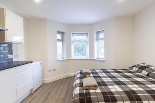 a bedroom with a bed and two windows at Radstock Road - Room 2b in Southampton