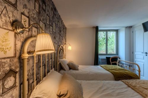 a bedroom with two beds and a stone wall at Maison Loustalet in Arzacq-Arraziguet