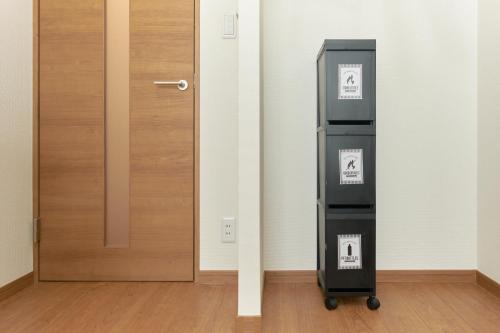 an empty room with a door and a luggage cart at Zenith Garden TOGOSHI in Tokyo