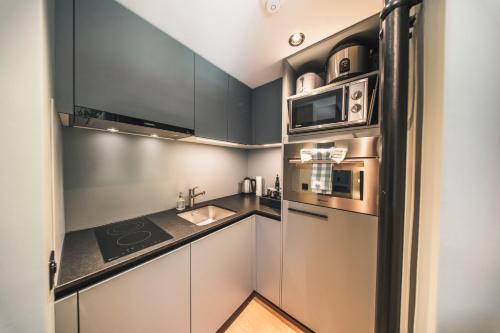 a kitchen with a sink and a microwave at HOP Apartments & Suites in Interlaken