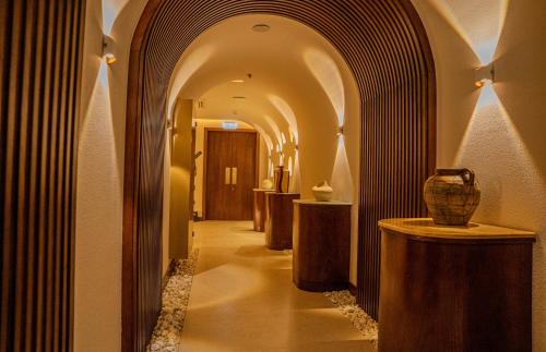 Un pasillo con un arco con un jarrón sobre una mesa. en Heritage Inn Hotel Apartments, en Al Wakrah