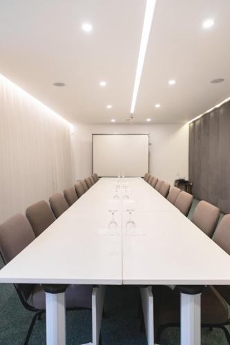 a conference room with a white table and chairs at Hotel Afa in Pristina