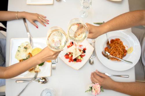 a group of people sitting at a table drinking wine at Hotel Afa in Pristina