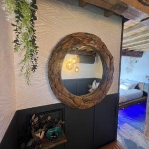 a room with a circular mirror on the wall at La Chambre Du Village 