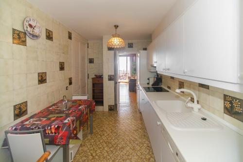 a kitchen with a counter and a table and a sink at WELCS APARTAMENTO 284 PDA con terraza y vistas in Caserío Bufagañas